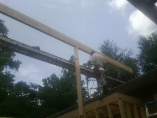 Carpenter setting a ridge beam over a new addition frame — Ice Dam Removal by Roofing Brothers in Markle