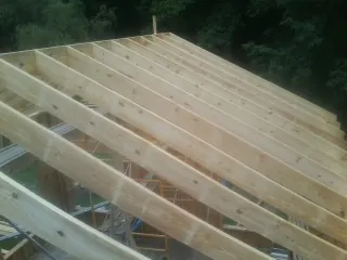 New roof rafters set over an addition before sheathing in Markle