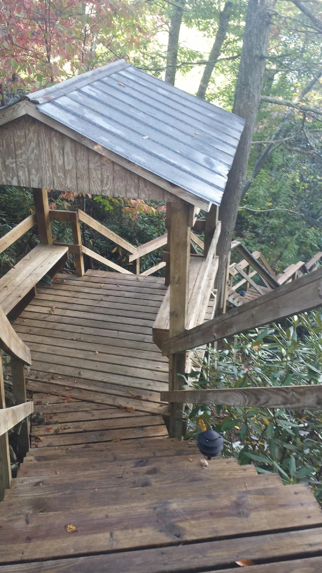 Metal roofed shelter over wooden steps on a wooded walkway — Skylight Repair & Installation work by our crew in Markle