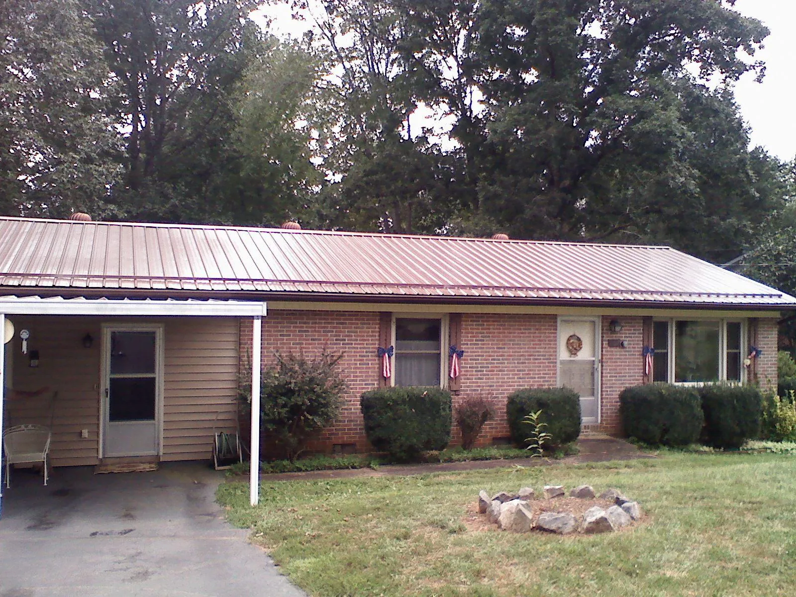 Bronze metal roof and carport on a brick ranch home — Roof Repair work by our crew in Markle